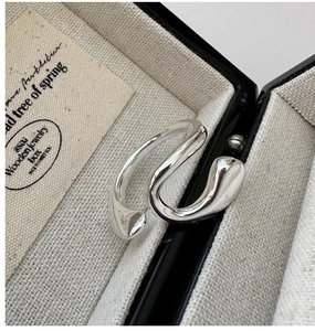 Macro detail of polished S925 sterling silver open ring with irregular wave design