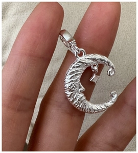 Macro detail of S925 sterling silver crescent moon and star pendant with vintage texture