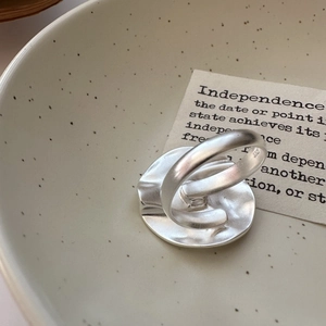 Matte S925 sterling silver ring with irregular hammered texture on a ceramic plate