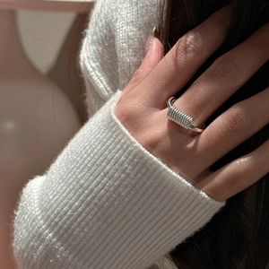 Minimalist S925 sterling silver ring featuring unique coil design on model hand