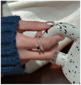Close-up of S925 sterling silver twist ring with black and clear zircon on a model hand