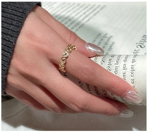 Detailed close-up of a gold-plated coin motif ring featuring hollowed round designs