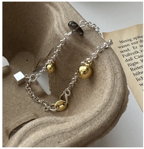 Vue macro du bracelet en argent S925 avec breloques dorées et détails en quartz fumé