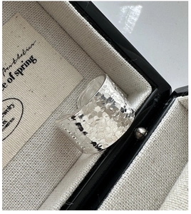 Détail d'une bague large en argent sterling S925 avec texture martelée dans son écrin