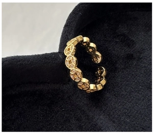 Macro shot of gold-plated silver ring with coin patterns and sparkling zircons