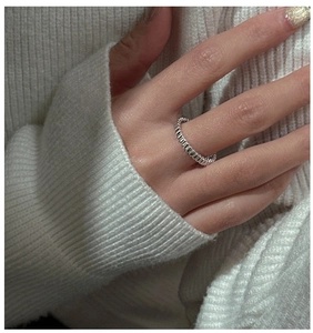 Close-up of S925 silver ring featuring vertical grooved texture on a knit sleeve