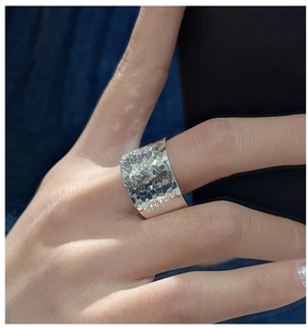 Détail d'une bague large en argent sterling S925 avec texture martelée effet glace