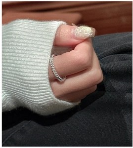 Macro view of sterling silver ring featuring a textured vertical ribbed design on model