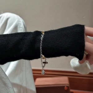Bracelet S925 argent avec perles dorées et pendentifs argentés sur poignet féminin