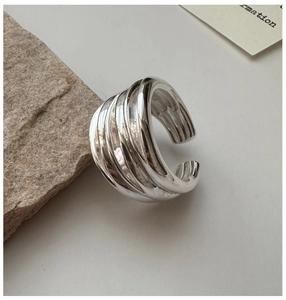 Detail of S925 sterling silver multi-layer textured wide ring on minimalist background