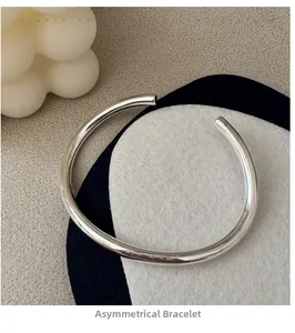 Close-up of minimalist S925 sterling silver irregular cuff bracelet with polished finish