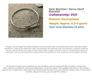 Detail of horseshoe-shaped S925 sterling silver knotted bangle on a grey stone surface