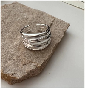Close-up of S925 sterling silver multi-layer intertwined ring on a natural stone base