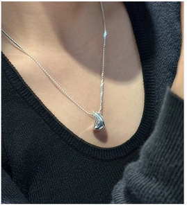 Gros plan d'un collier S925 en argent sterling avec pendentif goutte d'eau sur un mannequin