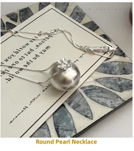 Détail du pendentif en argent brossé avec motif floral sur une chaîne gourmette