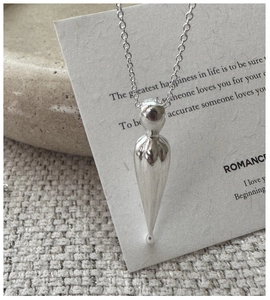 Macro detail of S925 sterling silver stamp on water drop pendant with textured finish