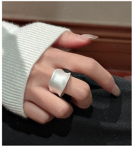 Detail van een brede S925 zilveren zadelring met een mat concaaf geometrisch oppervlak