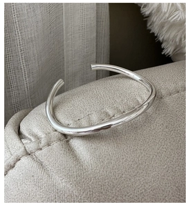 Close-up of polished S925 sterling silver open bangle showing smooth mirror finish
