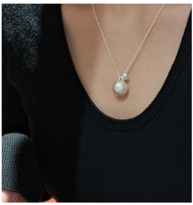 Detail of silver S925 sterling silver ball necklace with hammered texture on black sweater