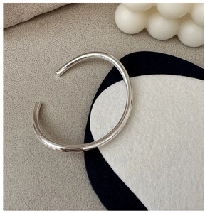 Detailed macro shot of S925 sterling silver open bangle showing hallmark and polished finish