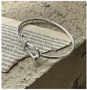 Macro detail of silver S925 horseshoe buckle bangle on vintage textured background
