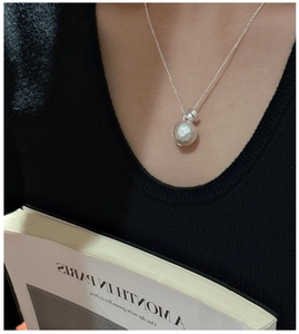Close-up of S925 sterling silver ball necklace with hammered texture on a black background