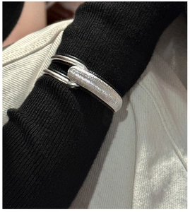 Detail of S925 sterling silver cuff bracelet with brushed texture on black sleeve