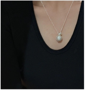 Detailed close-up of a faceted silver ball pendant on a minimalist S925 sterling silver chain