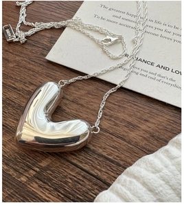 Macro detail of polished S925 sterling silver heart pendant with AG925 hallmark