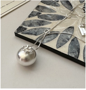 Détail macro du pendentif sphère en argent S925 et de l'étiquette gravée AG925