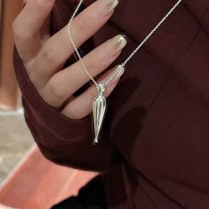 Minimalist S925 sterling silver water drop pendant necklace shown on red sweater