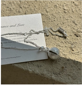 Detail view of S925 sterling silver ball necklace with AG925 stamp on textured stone
