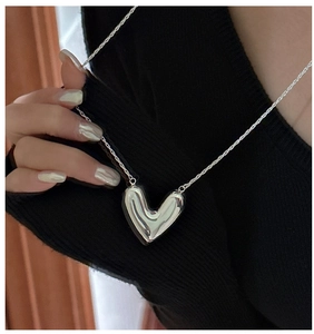 Polished S925 sterling silver heart pendant necklace on model with black sweater