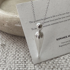 Minimalist S925 sterling silver matte teardrop pendant necklace on artistic paper