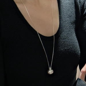 Collier minimaliste en argent sterling 925 avec pendentif grenade sur un pull noir