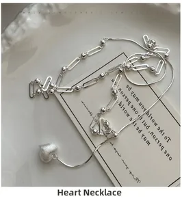 Detail of S925 sterling silver heart necklace with brushed texture on textured ceramic