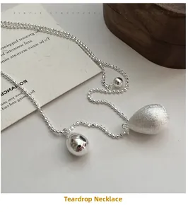 Détail d'une chaîne à billes en argent S925 avec pendentifs en forme de goutte polis