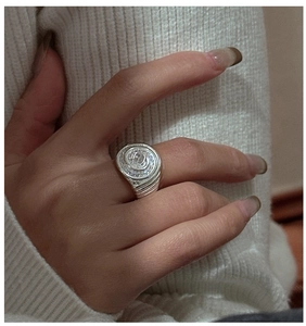 Macro detail of S925 silver spiral ring with rectangular zircon and pavé setting