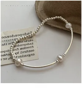 Macro detail of S925 sterling silver beaded bracelet with pearls on a vintage background