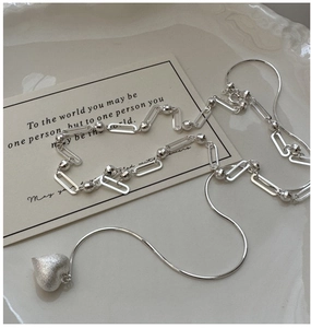 Detail of S925 sterling silver heart pendant necklace on a ceramic jewelry tray