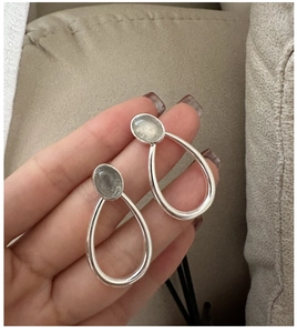Detailed view of S925 silver labradorite teardrop earrings held in hand for scale