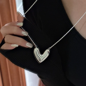 Minimalist S925 sterling silver heart pendant necklace on black knit background