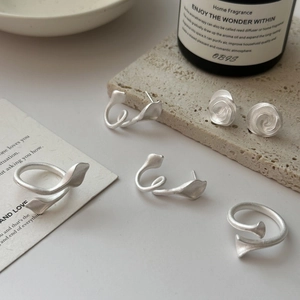 Minimalist matte silver earring and ring set displayed on stone with aesthetic decor