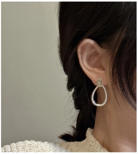 Close-up of minimalist S925 sterling silver drop earrings on model with labradorite stone