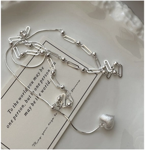 Detailed macro view of S925 silver paperclip chain with a brushed heart pendant