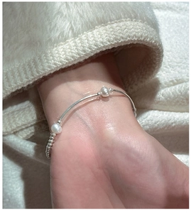 Close-up of S925 sterling silver pearl bracelet on model's wrist with minimalist design