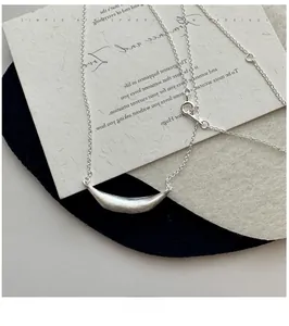 Macro detail of S925 sterling silver smile necklace featuring a brushed metal bar pendant