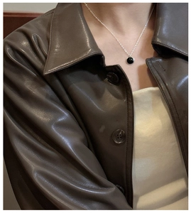 Close-up of minimalist S925 silver necklace with a black onyx pendant on a model