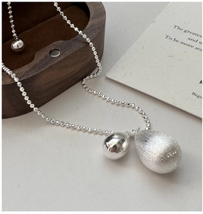 Détail du collier S925 avec bille polie et pendentif goutte d'eau à la texture mate