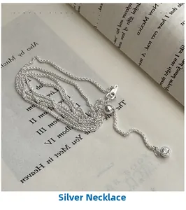 Macro detail of silver Chopin sweater chain with sparkling round zircon pendant